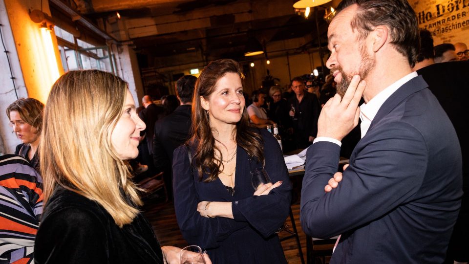 Lene Mueller-Stöfen, Sonja Heiss & Jonas Dornbach stehen in einem Kreis und reden miteinander.
