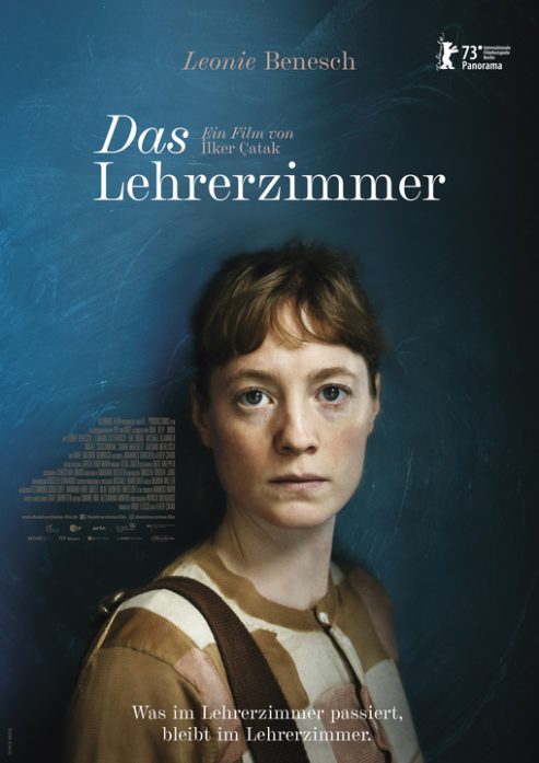 Kinoplakat zum Film DAS LEHRERZIMMER. Eine junge Frau blickt mit direkt in die Kamera. Sie trägt eine braune Bluse mit Muster. Im oberen Bilddrittel der Schriftzug DAS LEHRERZIMMER